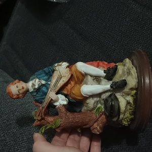 resin figurineon round wooden support. In good condition.Dimensions: 19 x 11